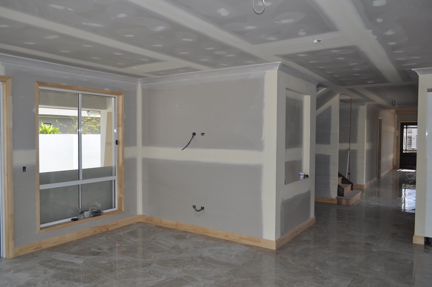 Unpainted wall lining showing joints beside a window
