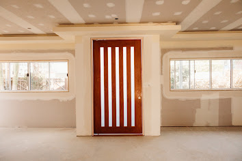 Unpainted square-set wall-to-ceiling junction beside a window