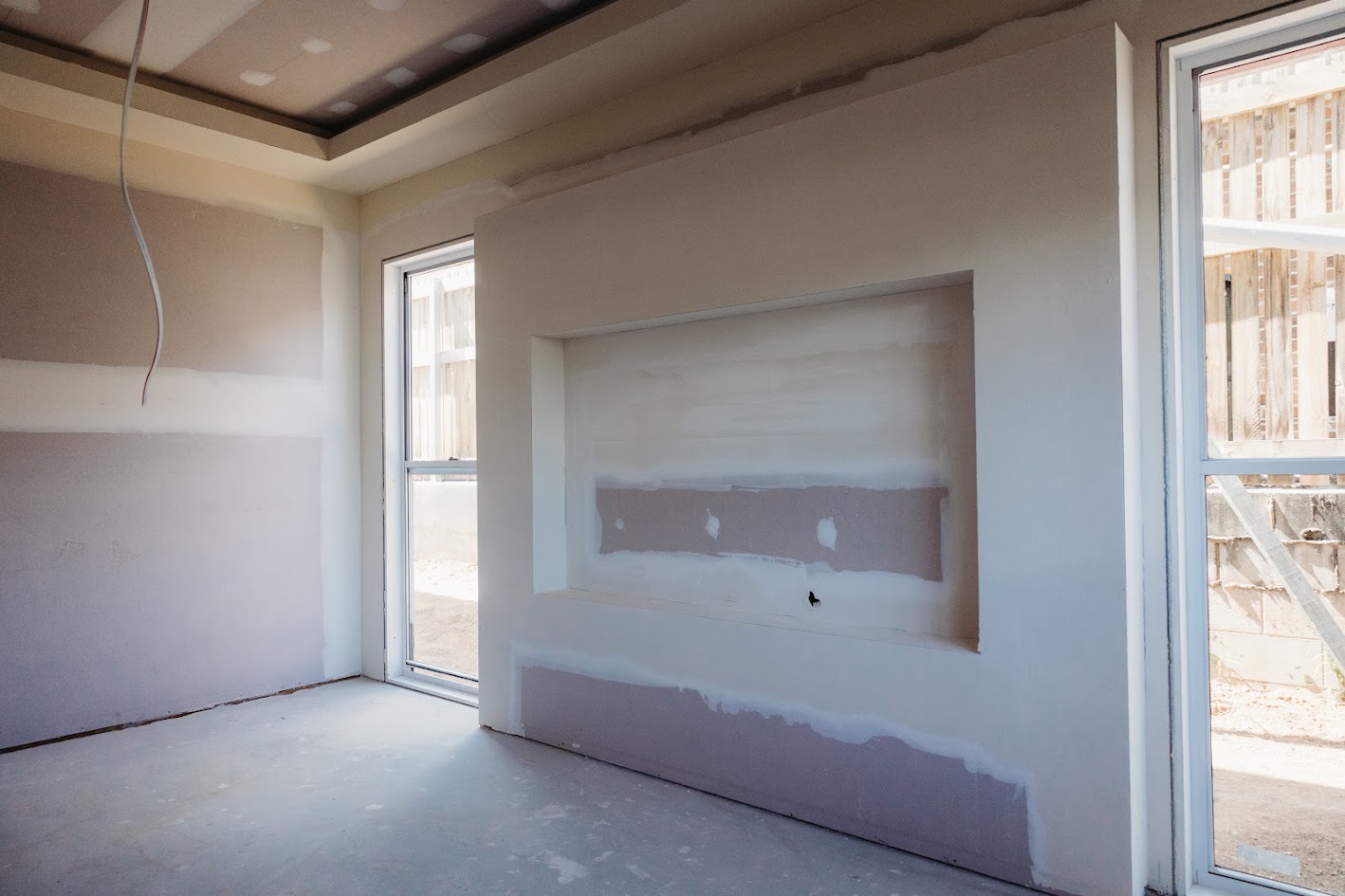 Plasterboard-lined room with a recessed wall feature during interior finishing